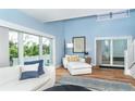 Bright living room featuring large windows, hardwood floors, and stylish, comfortable white furniture at 6005 N Beach Rd # 16, Englewood, FL 34223