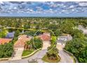 Aerial view showcasing the home's tile roof and the surrounding neighborhood with a scenic pond at 6610 Rosy Barb Ct, Lakewood Ranch, FL 34202