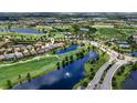 Expansive aerial view of a golf course community, highlighting water features, the green, and lush scenery at 7634 Windy Hill Cv, Bradenton, FL 34202