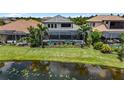 Aerial shot of backyard with screened pool, lush landscaping, and scenic water view at 7634 Windy Hill Cv, Bradenton, FL 34202