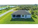 Aerial view of backyard featuring a screened-in patio and overlooking a lush green lawn at 8045 Bosco Rd, Port Charlotte, FL 33981