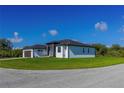 Contemporary home showcasing a well-maintained lawn and architectural design on a sunny day at 8045 Bosco Rd, Port Charlotte, FL 33981