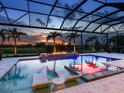 Gorgeous screened pool with a built-in fire pit and comfortable lounge chairs offers a relaxing outdoor experience at 16917 Clearlake Ave, Lakewood Ranch, FL 34202