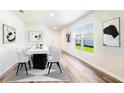 Bright dining room features contemporary table, white chairs, and modern art, with large window views at 17385 Whiskey Creek Trl, Parrish, FL 34219