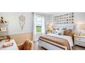 Bright bedroom featuring neutral tones, a comfortable bed with decorative pillows, and ample natural light at 18329 Thistleberry Pl, Lakewood Ranch, FL 34211