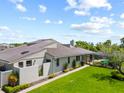 Back exterior view showcasing a green lawn and a screened-in pool area at 2181 Harbourside Dr # 1403, Longboat Key, FL 34228