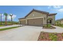 Beige two-car garage with manicured landscaping and paved driveway in a sunny Florida community at 248 Altamura Cir, Nokomis, FL 34275