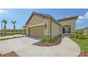 Beige two-car garage with a paved driveway and manicured landscaping in a Florida home at 248 Altamura Cir, Nokomis, FL 34275
