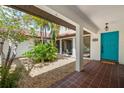 Charming courtyard featuring a blue door, red tile roof, and lush palm trees at 2504 Tanglewood Dr, Sarasota, FL 34239