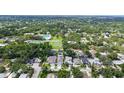 Birds-eye view of a neutral-colored home showcasing it's neighborhood, lush backyard, and proximity to recreation at 2590 Floyd St, Sarasota, FL 34239