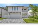 Stunning two-story modern home with a gray brick driveway and pergola over the garage at 2590 Floyd St, Sarasota, FL 34239
