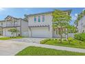 Beautiful two-story home with a gray driveway, a pergola over the garage, and manicured landscaping at 2590 Floyd St, Sarasota, FL 34239