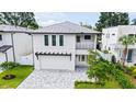 A modern home with a light gray brick driveway and a pergola over the garage at 2590 Floyd St, Sarasota, FL 34239
