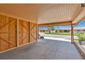 View of the covered carport, featuring a painted floor and access to wooden storage at 3850 Catalina Dr, Bradenton, FL 34210