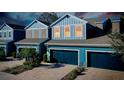 Blue townhome featuring a two-car garage and brick-paved driveway, viewed from an elevated position at 4532 Chinkapin Dr, Sarasota, FL 34232