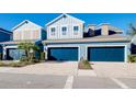 Charming blue townhome showcasing the attached two-car garage and brick-paved driveway at 4532 Chinkapin Dr, Sarasota, FL 34232