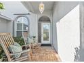 Inviting front porch with seating, brick flooring, and a decorative glass front door at 5206 19Th W Ave, Bradenton, FL 34209