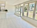 Enclosed sunroom with bright white interior, tiled floors, bar, and large windows overlooking the backyard at 544 Mount Vernon Dr, Venice, FL 34293