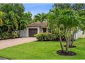 Landscaped front yard with a well-maintained lawn and a paved driveway leading to the garage at 5702 Tangerine S Ave, Gulfport, FL 33707