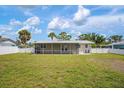 Expansive backyard featuring a screened-in lanai, perfect for outdoor living and entertaining with a well manicured yard at 609 Carmel Rd, Venice, FL 34293