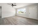 Bright and airy living room with light gray flooring, ceiling fan, and a large window providing ample natural light at 609 Carmel Rd, Venice, FL 34293