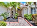 Home's entrance with well-maintained landscaping and brick walkway create a welcoming entrance at 6312 41St E Ct, Sarasota, FL 34243