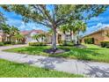 Well-maintained home featuring beautiful landscaping, mature trees, and a red tile roof at 6312 41St E Ct, Sarasota, FL 34243