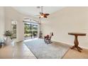 Bright living room with tile floors, ceiling fan and glass sliding door to backyard at 6312 41St E Ct, Sarasota, FL 34243