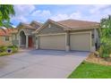 Beautiful home exterior showcasing a well-maintained lawn, tiled roof, and three-car garage at 695 Rivendell Blvd, Osprey, FL 34229
