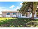 Charming single-story home with an attached two-car garage framed by a lush green lawn and swaying palm tree at 7164 Gama Ct, North Port, FL 34287