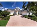 Beautiful one story home with lush landscaping, brick driveway, and a two-car garage at 7211 Marston Ct, University Park, FL 34201