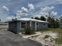 Side view of a single-story house with a metal roof and tidy landscaping at 811 24Th Street E Ct, Bradenton, FL 34208