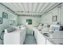 Clean and organized laundry room featuring multiple washing machines and ample space at 999 Inlet Cir # 103, Venice, FL 34285