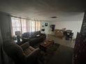 Cozy living room features a dark leather sofa, neutral walls and lots of natural light at 11234 Areca Dr, Port Richey, FL 34668
