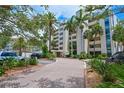 Beautiful condo building with tropical landscaping and a circular driveway leading to the main entrance at 1510 1St W Ave # 102, Bradenton, FL 34205
