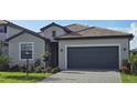 Charming single-Gathering home featuring a gray two-car garage and lush landscaping at 15115 Oxford Grey Dr, Bradenton, FL 34211
