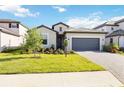 Inviting single-story home featuring a paved driveway, two-car garage, and manicured landscaping at 15115 Oxford Grey Dr, Bradenton, FL 34211