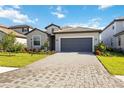 Single-story home with a paver driveway, a two-car garage, and well-maintained landscaping at 15115 Oxford Grey Dr, Bradenton, FL 34211