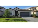 Well-maintained home boasts fresh landscaping, a gray two-car garage, and paved driveway at 15115 Oxford Grey Dr, Bradenton, FL 34211
