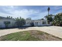 The house features a white exterior, big windows, and a circular driveway at 205 55Th Ave, St Pete Beach, FL 33706