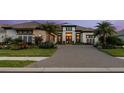 Beautiful home with a stone paver driveway, tropical landscaping, and a charming exterior lighting at 3936 Santa Caterina Blvd, Bradenton, FL 34211