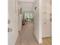Bright hallway with wood-look floors, white trim, and cabinets leads to a living area with a view at 4380 Exeter Dr # 204, Longboat Key, FL 34228