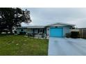 Charming single-story home with a well-manicured lawn, a bright blue garage door, and inviting front patio at 453 Sandlewood Dr, Venice, FL 34293