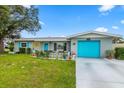 Charming single-story home with a well-manicured lawn, a bright blue garage door, and inviting front patio at 453 Sandlewood Dr, Venice, FL 34293
