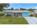Charming single-story home with a well-manicured lawn, a bright blue garage door, and inviting front patio at 453 Sandlewood Dr, Venice, FL 34293
