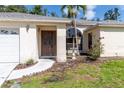 A welcoming home entrance features a well-maintained lawn, mature plantings and a decorative water feature at 4805 Cypress Lake Ct, Sarasota, FL 34243