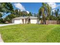 Beautiful one-story home boasting a lush front lawn, complemented by mature palm trees and a fenced yard at 4805 Cypress Lake Ct, Sarasota, FL 34243