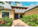 Close up of the front door and landscaping of a tan house with beautiful terra-cotta colored roof at 4916 Tivoli Run, Bradenton, FL 34211