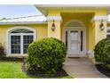 Inviting entryway featuring a decorative front door, sidelights, and manicured landscaping at 6114 68Th E Dr, Palmetto, FL 34221