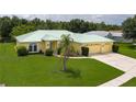 Inviting yellow home with a green metal roof, well-manicured lawn, and a spacious driveway at 6114 68Th E Dr, Palmetto, FL 34221